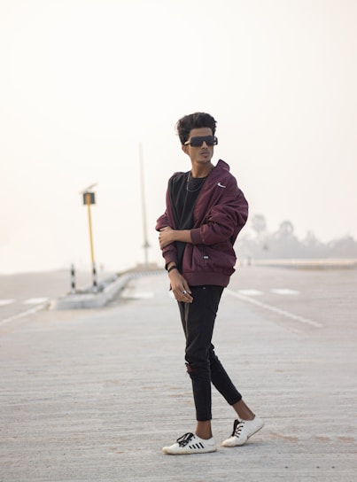 A confident young person wearing stylish clothes, standing in an urban setting with a determined look.