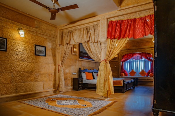 Spacious room featuring a golden-hued carpet and matching decorative pillows.
