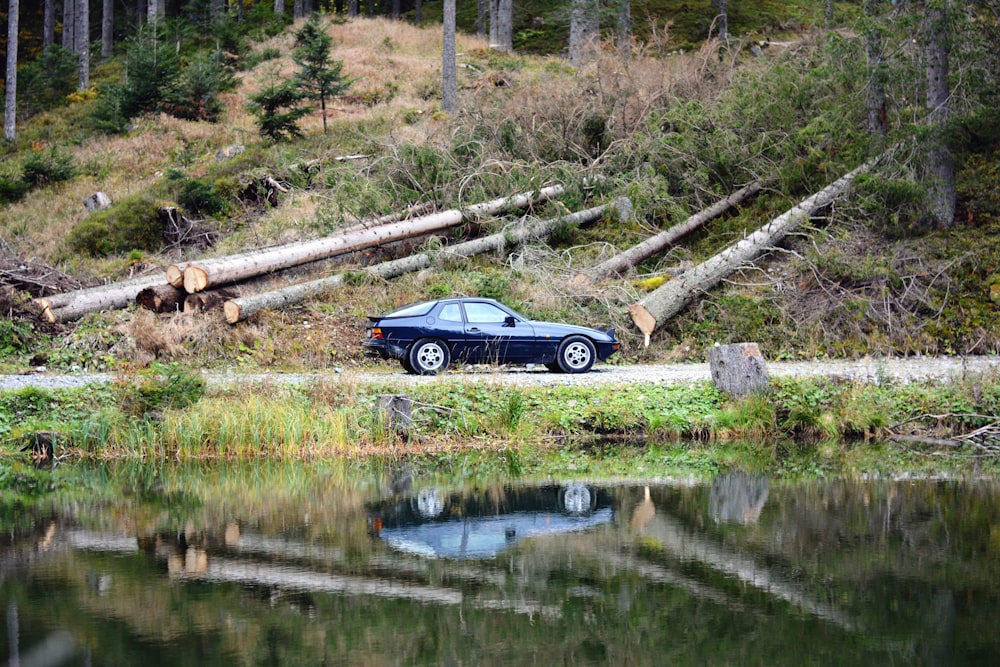 a car parked on the side of a road next to a lake