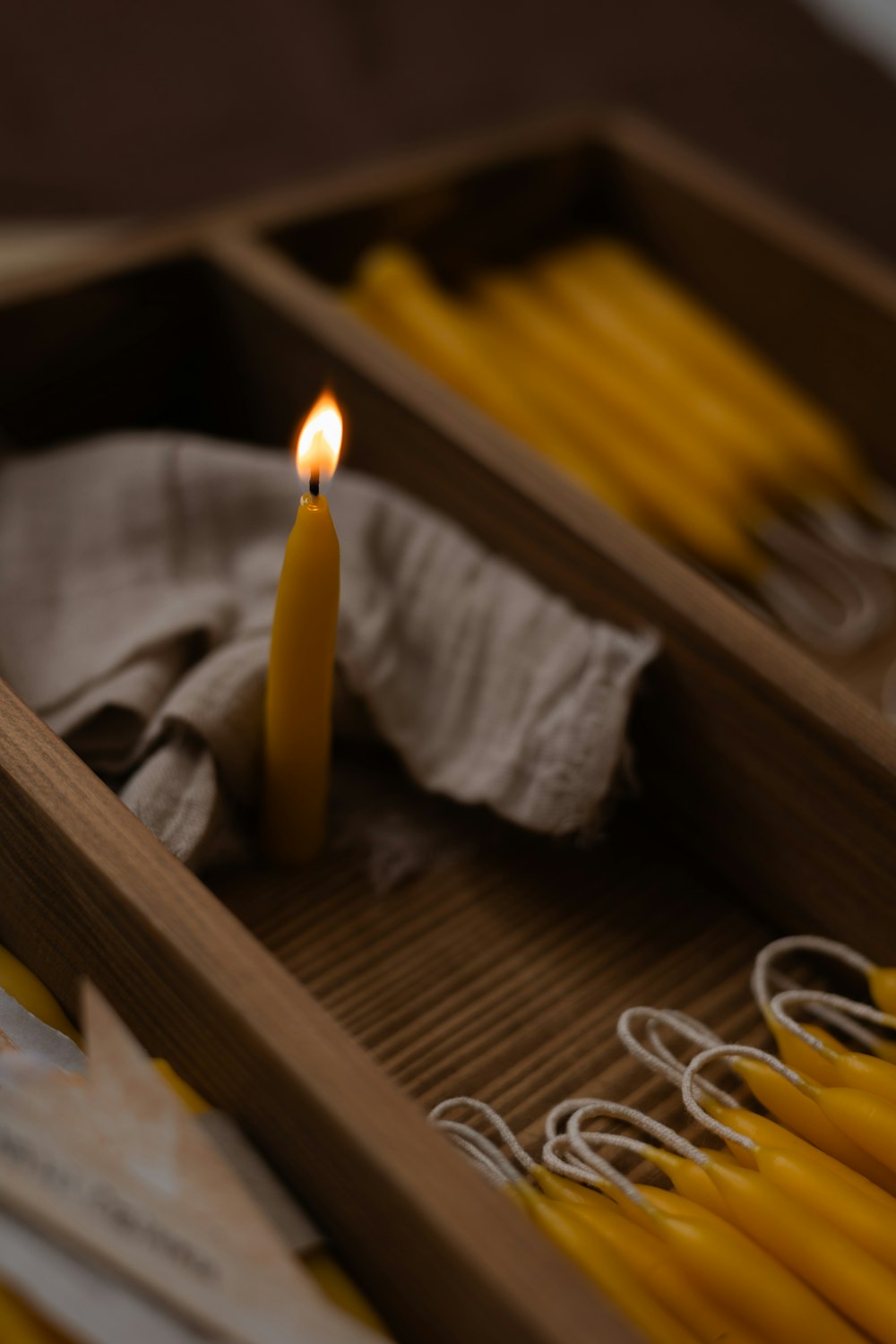 a lit candle sitting in a wooden box