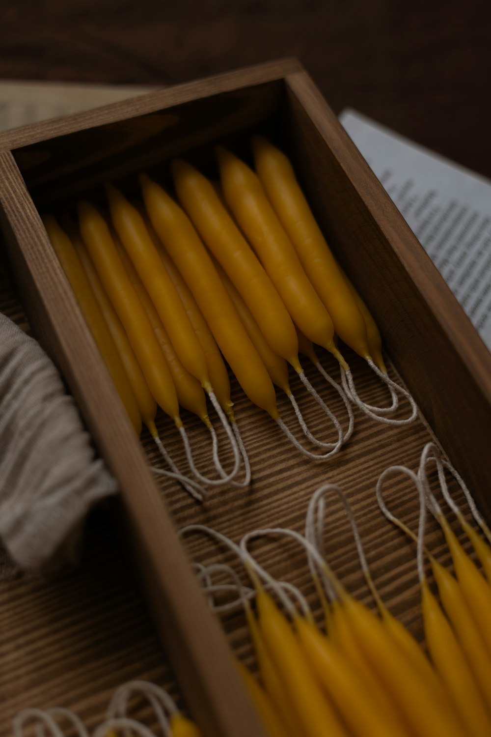 a box filled with yellow candles next to a book