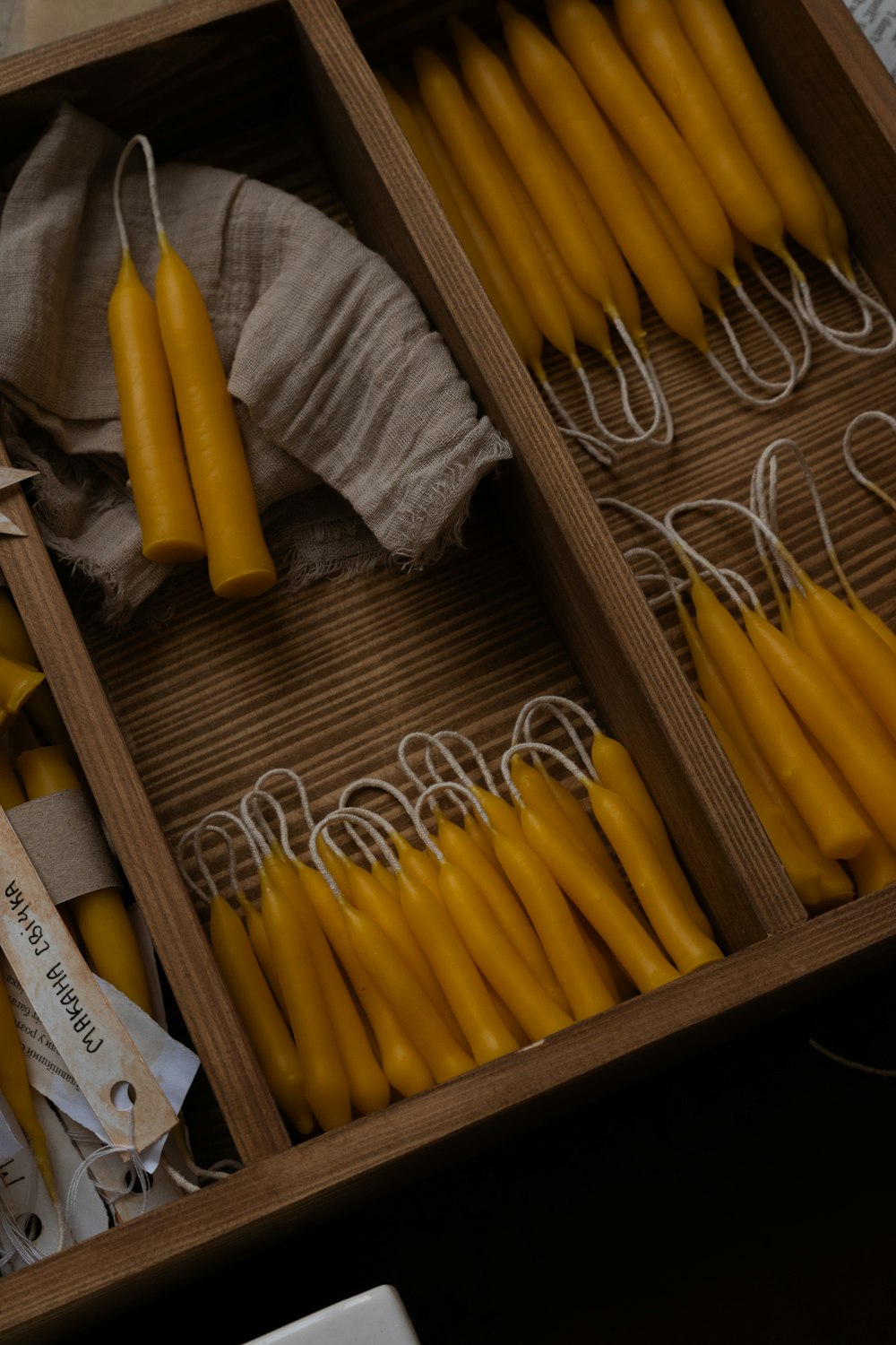 a wooden box filled with yellow candles on top of a table