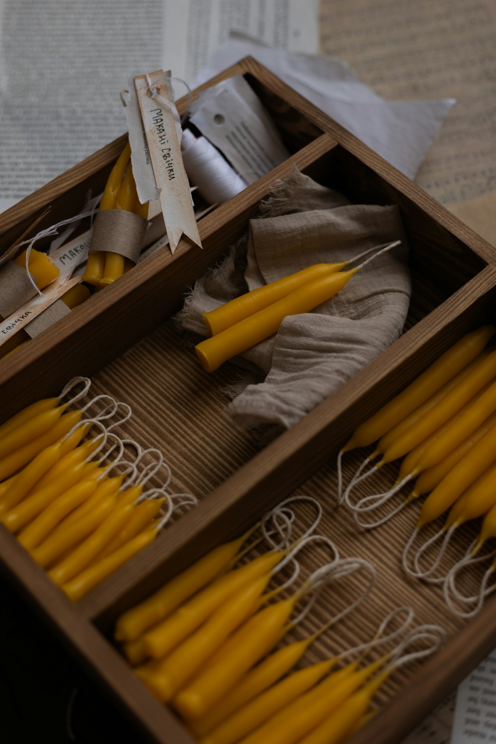 a wooden box filled with yellow candles on top of a table