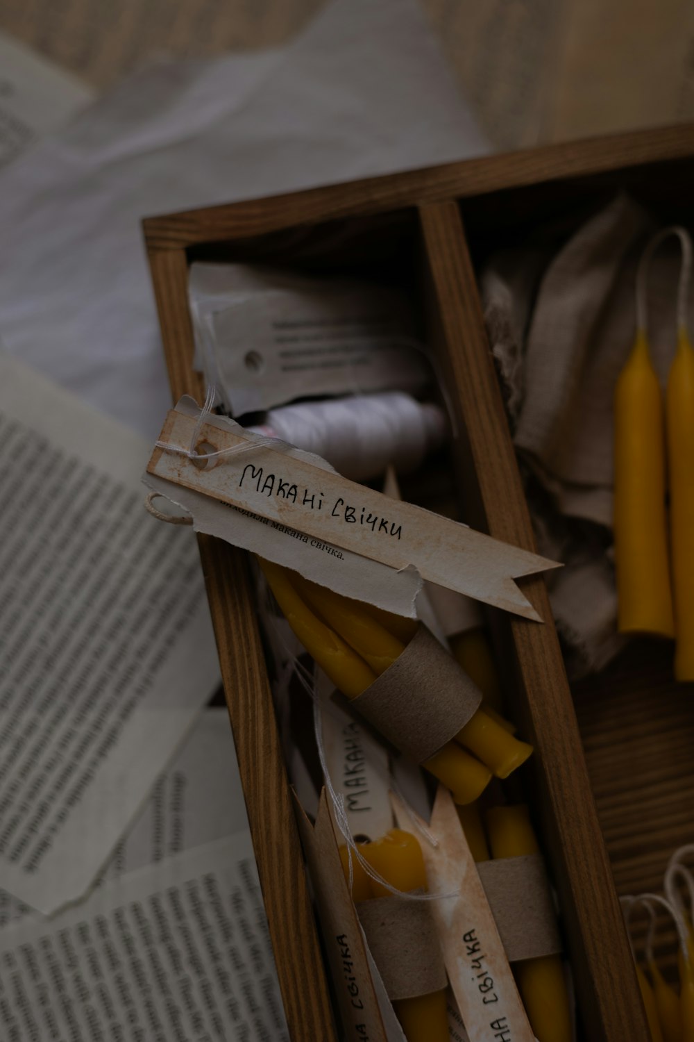 a box filled with yellow candles next to a book