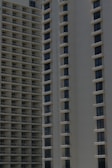 Two high-rise apartment buildings with multiple floors, featuring uniformly spaced windows and balconies.