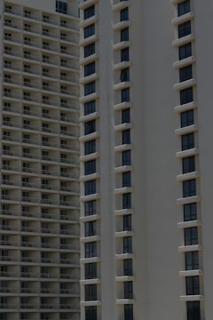Two high-rise apartment buildings with multiple floors, featuring uniformly spaced windows and balconies.