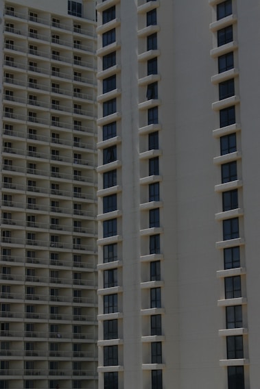 Two high-rise apartment buildings with multiple floors, featuring uniformly spaced windows and balconies.