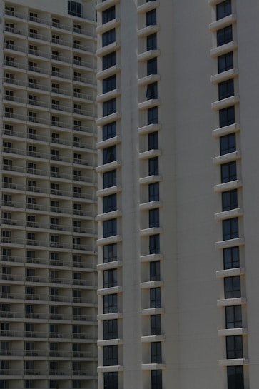 Two high-rise apartment buildings with multiple floors, featuring uniformly spaced windows and balconies.