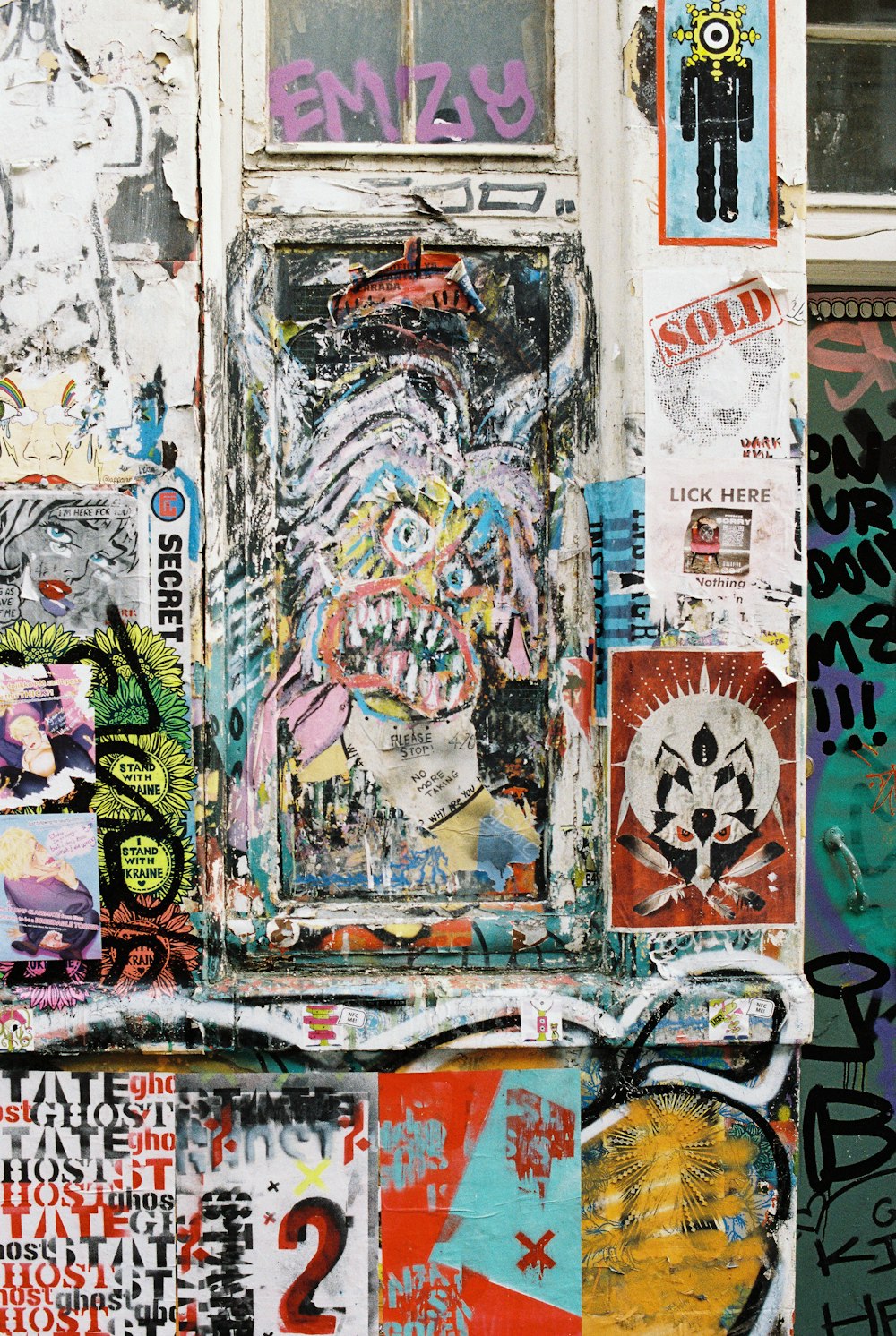 a wall covered in graffiti and stickers