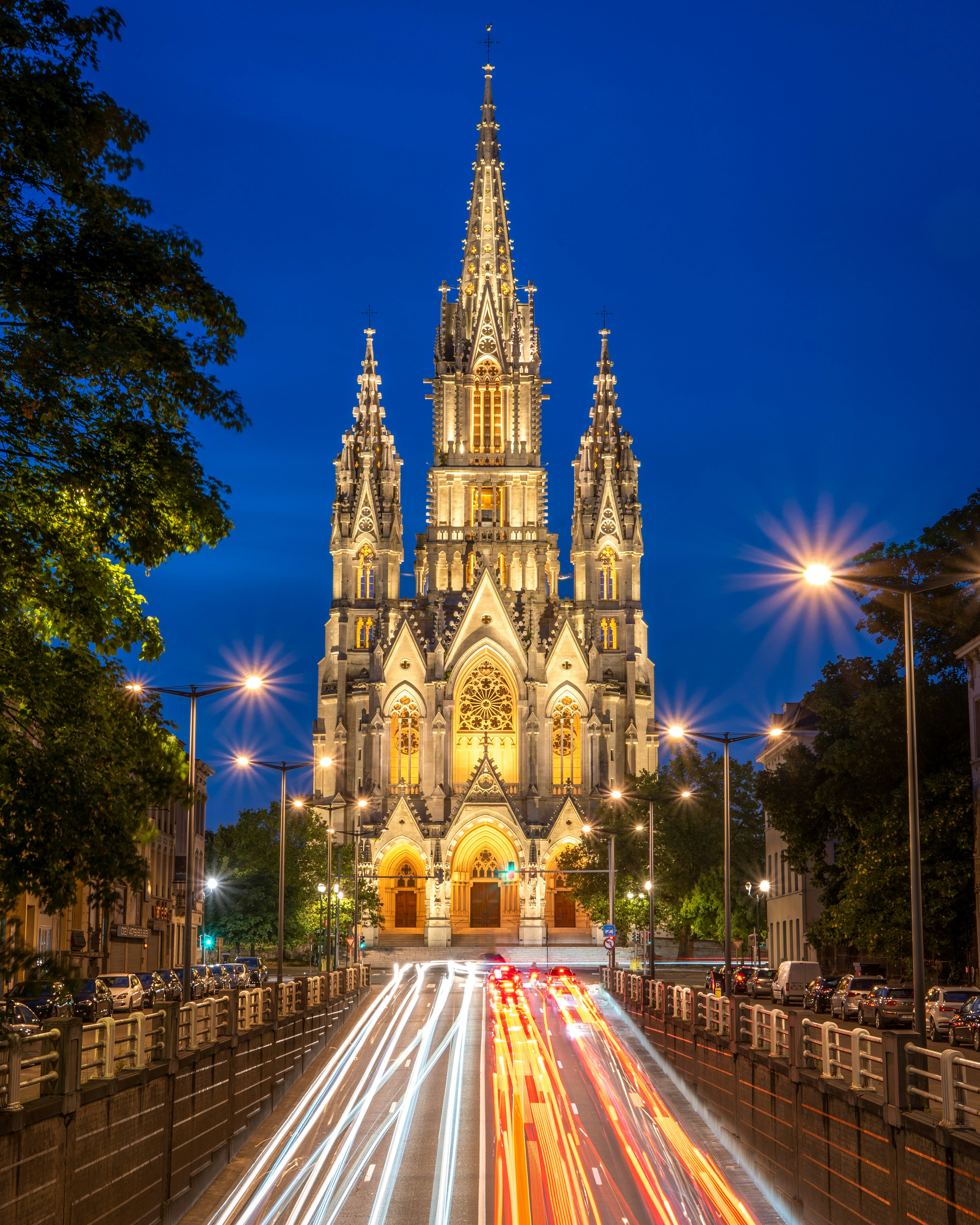 uma grande catedral com uma torre do relógio à noite