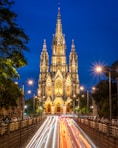 a large cathedral with a clock tower at night