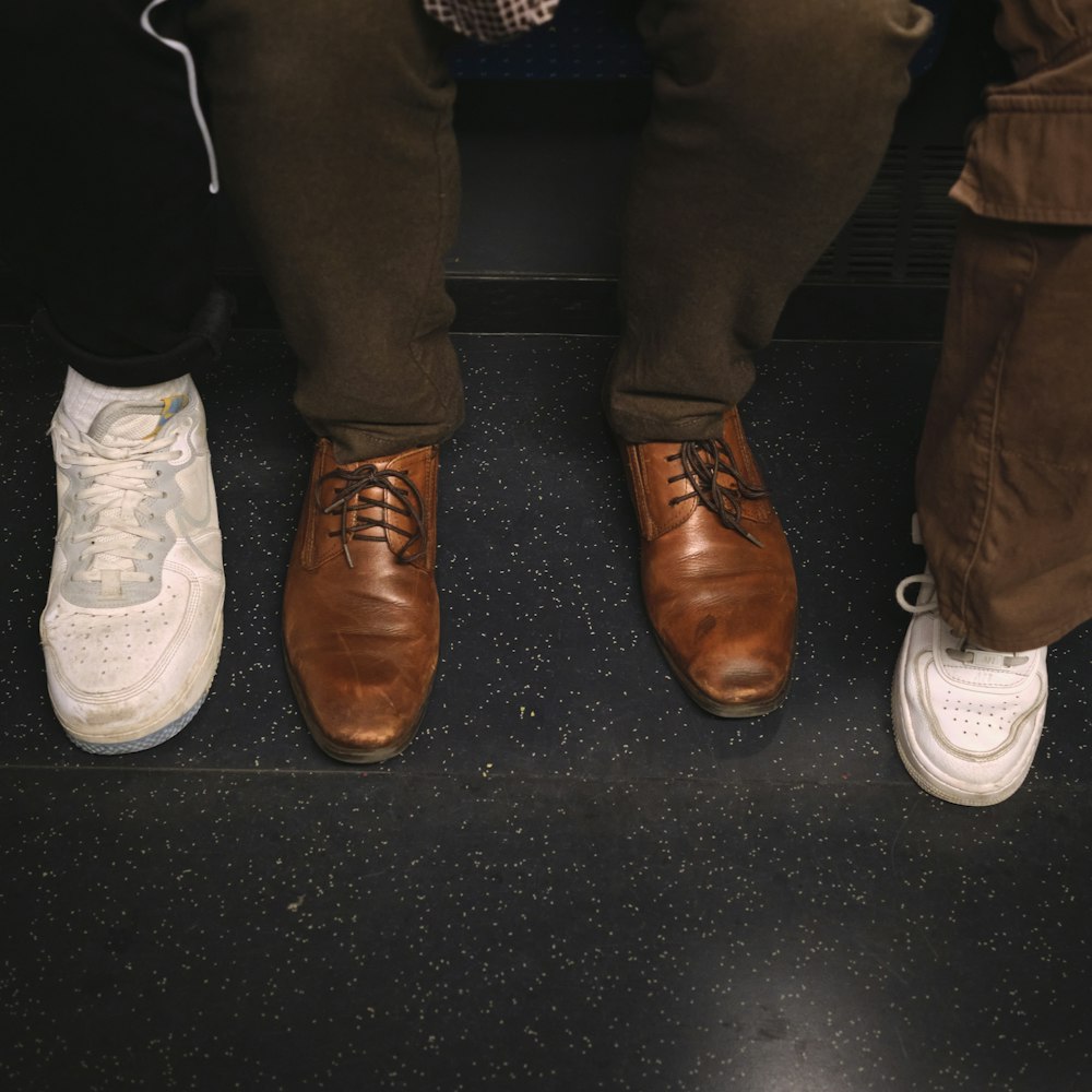 three people standing next to each other wearing brown and white shoes