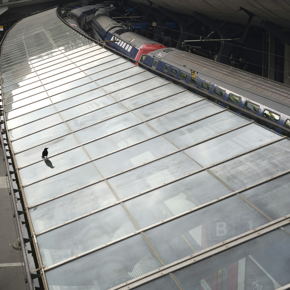 a train traveling down tracks next to a tall building