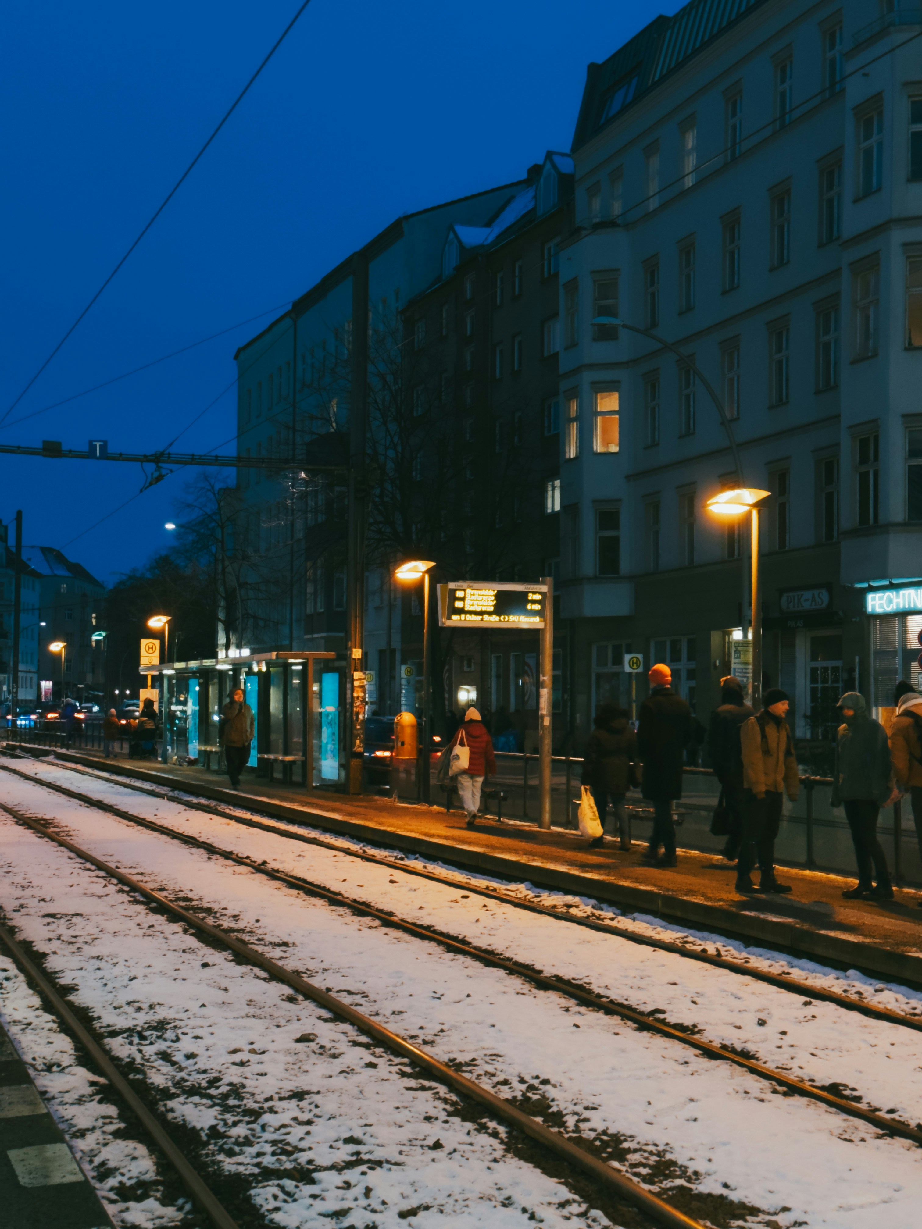 a group of people standing on the side of a train track