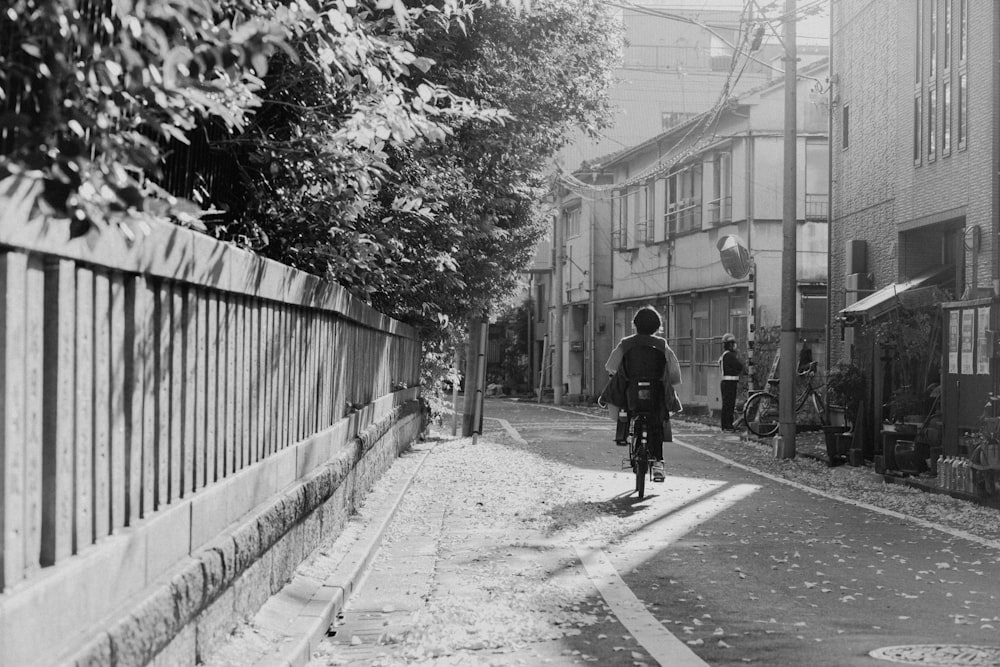 Ein Mann fährt mit dem Fahrrad eine Straße neben hohen Gebäuden entlang