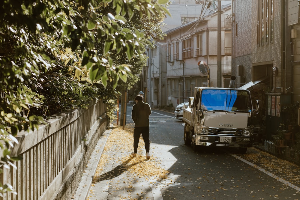 a man standing next to a truck on the side of a road