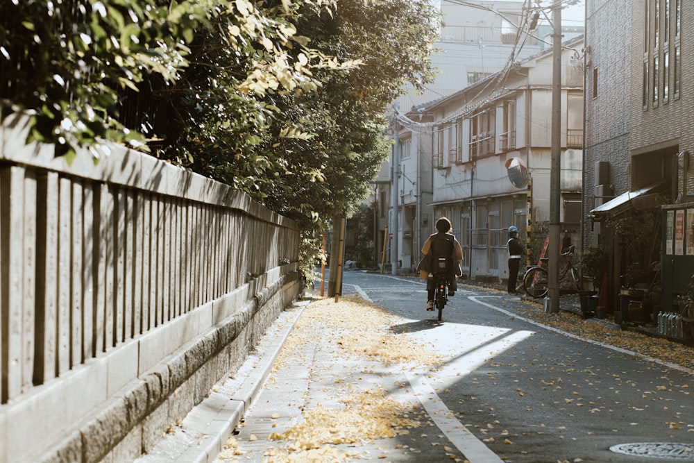 a man riding a bike down a street next to tall buildings