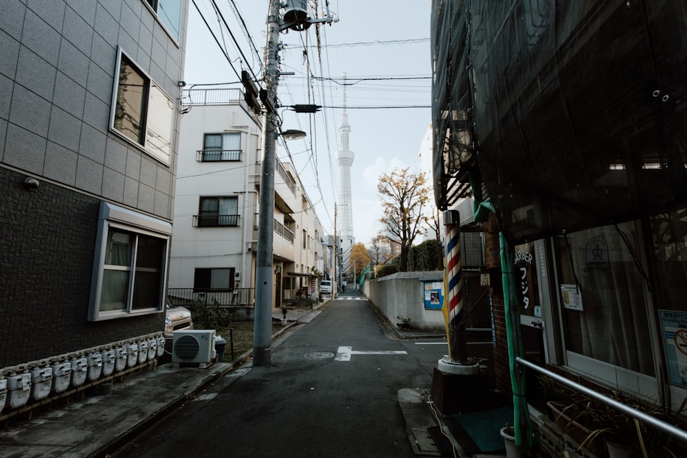 a narrow city street with power lines above it