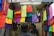 A customer browsing through a collection of colorful fabrics in a well-lit shop.