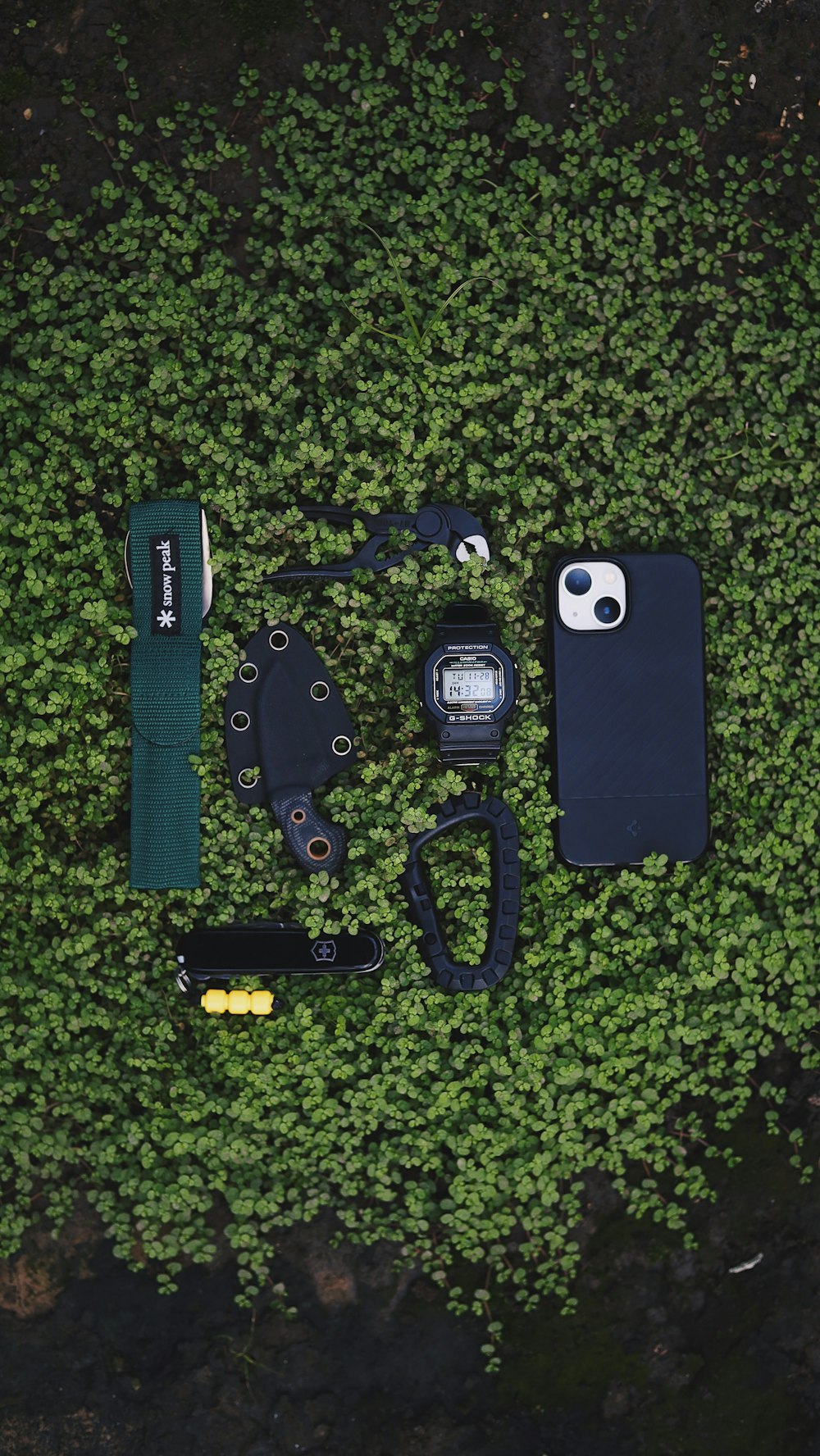 a cell phone laying on top of a lush green field