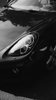 Close-up of a sleek black sports car with a flawless glossy finish under natural light