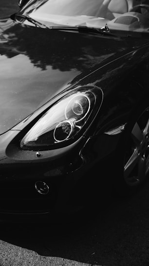 Close-up of a sleek black sports car with a flawless glossy finish under natural light