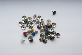 Close-up of colorful metal pins featuring popular character designs arranged on a corkboard.