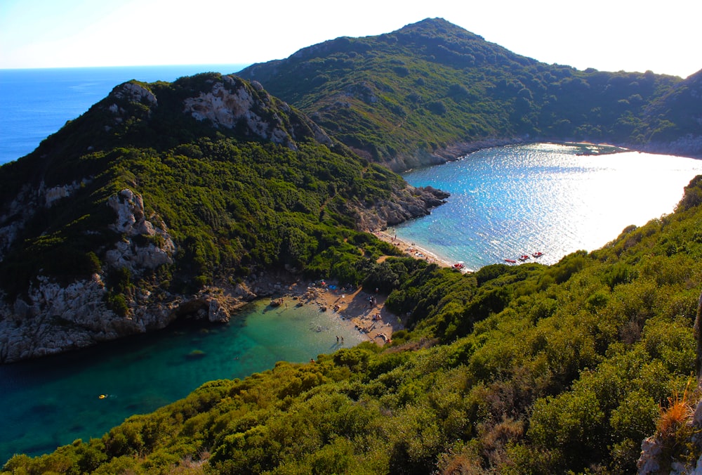 a large body of water surrounded by a lush green hillside