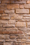 Close-up of textured stone facade blending naturally with oak wood accents.