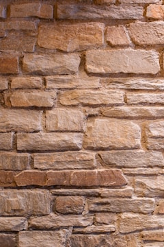 Close-up of a textured red rock wall with natural variations in color and shape.