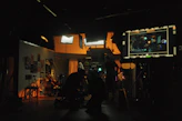 A warm, candid photo of the Latinart Studios team collaborating in a bright, colorful workspace filled with film and design equipment.