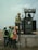 Workers wearing safety helmets and vests inspecting industrial equipment outdoors.