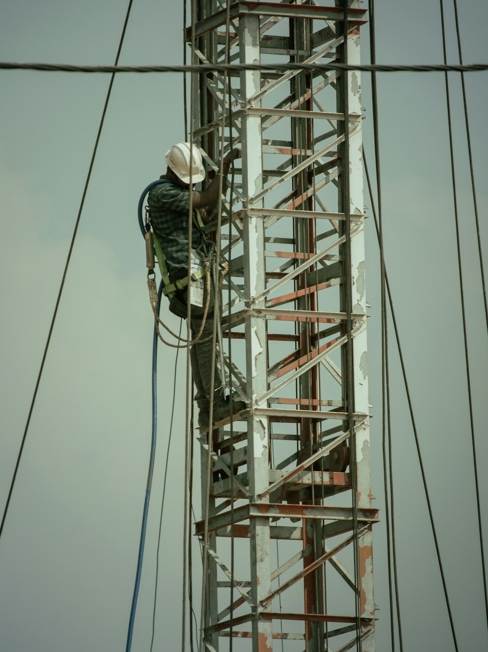 a man in a hard hat working on a power pole