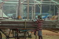 A man carrying Shuttering in his cart