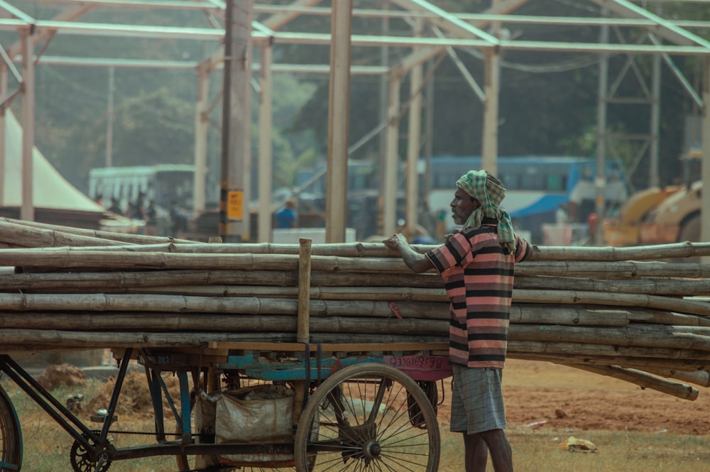 a man standing next to a wooden cart