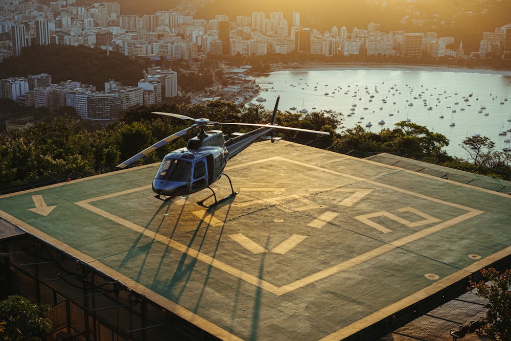 a helicopter sitting on top of a tarmac next to a body of water