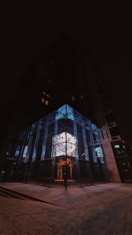 A sleek modern digital advertising totem glowing in an urban business environment at dusk.
