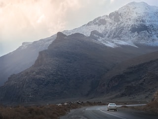A premium taxi driving through scenic mountain roads near Grenoble.