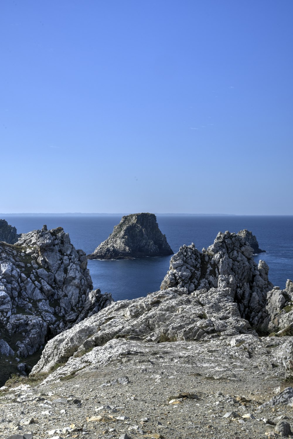 a rocky outcropping with a body of water in the background