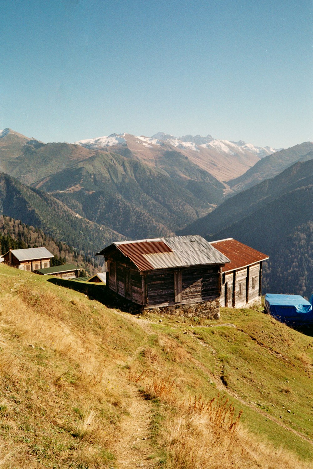 a house on a hill with mountains in the background