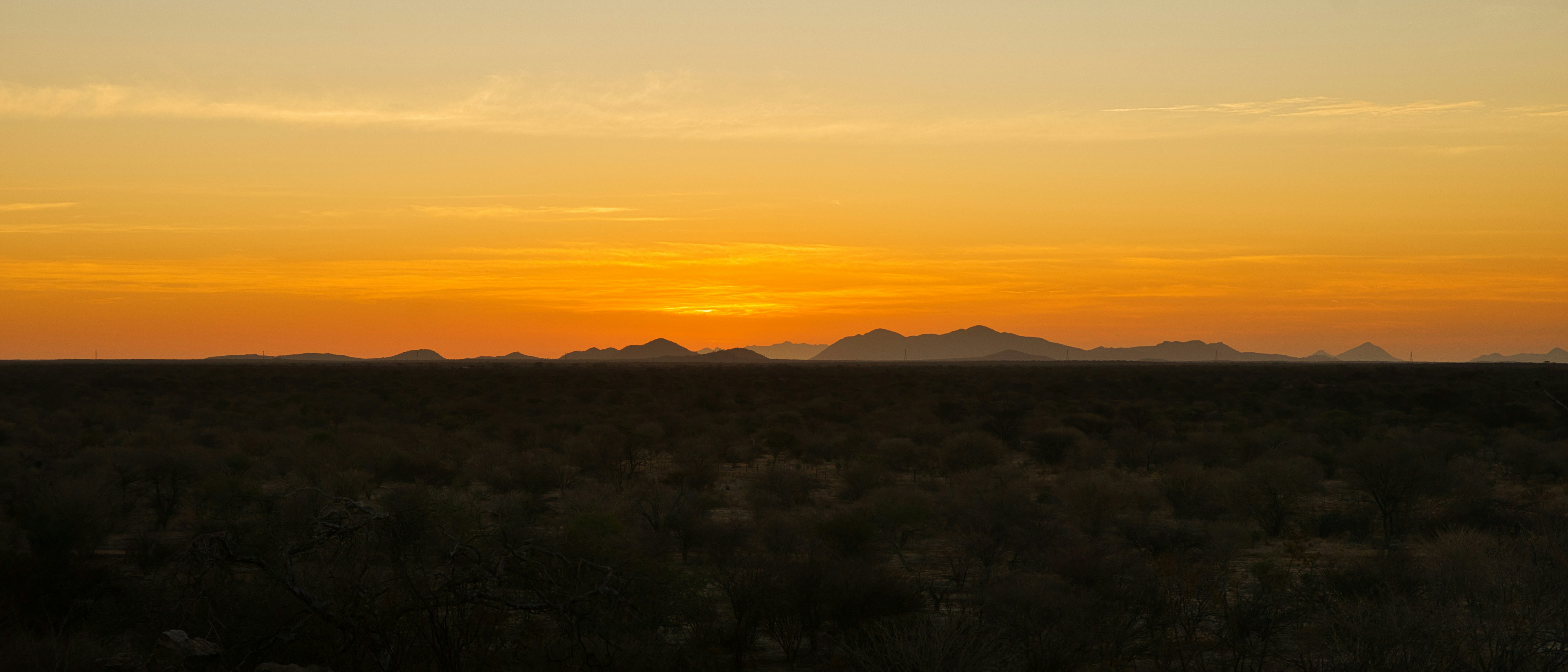 the sun is setting over the mountains in the desert