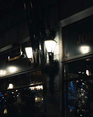 Cozy golden-lit mahala street at dusk with warm glowing lamps and intricate black and gold decorations.