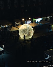 Evening festival atmosphere with illuminated pop-e stations glowing warmly.