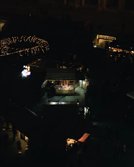 A vibrant marketplace scene showing solar street lights illuminating village roads at dusk.