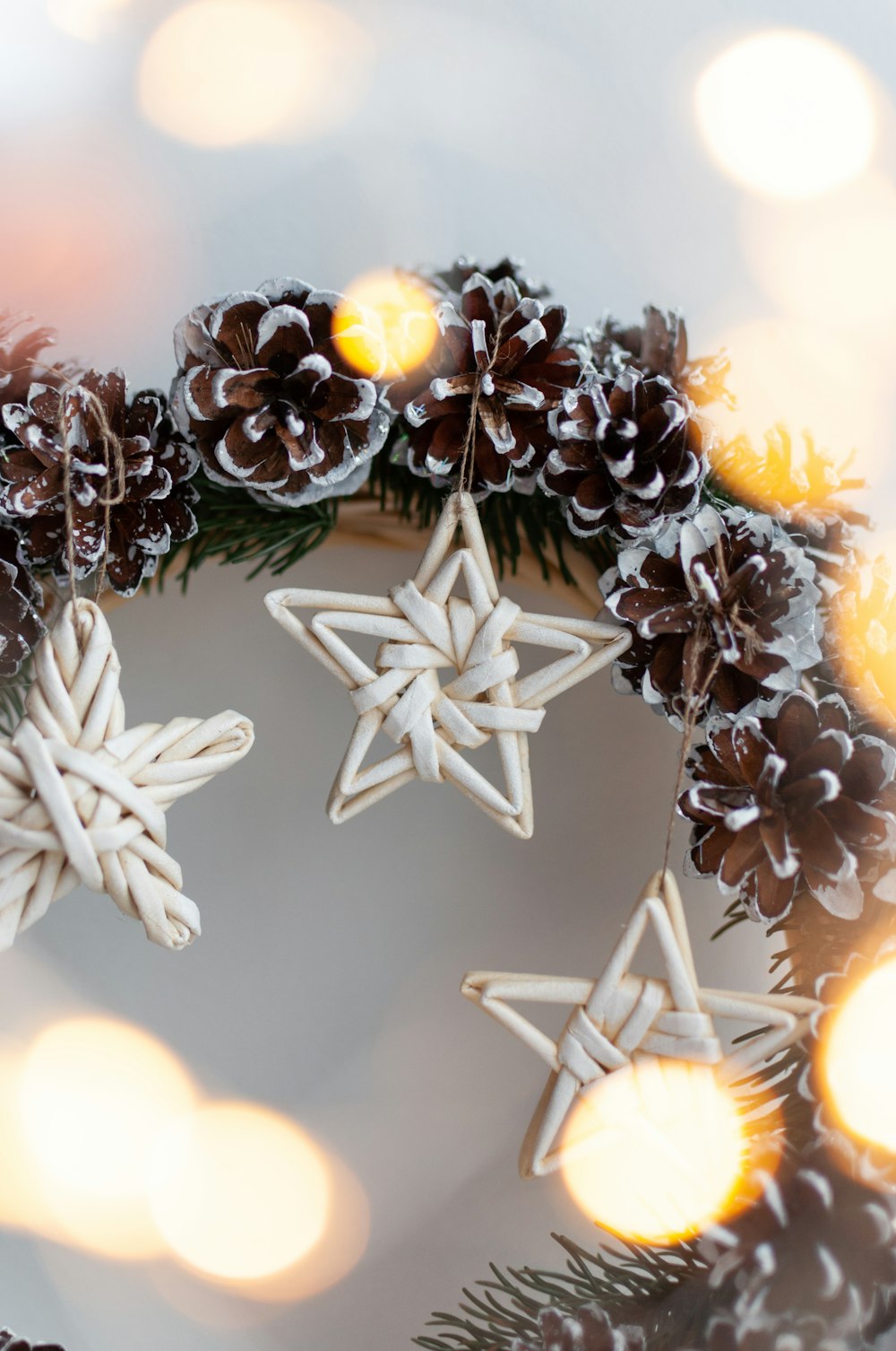 a close up of a wreath with snowflakes and pine cones