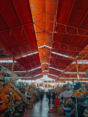 A sleek modern food market interior with deep ripe crimson accents and fresh produce displays.