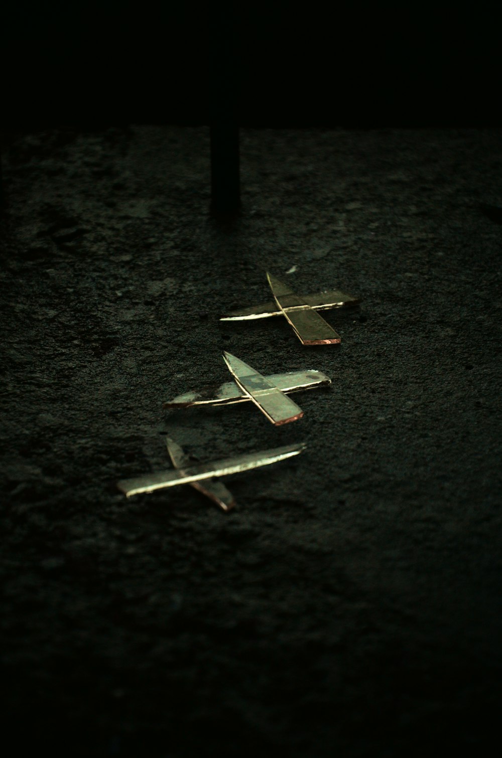 a row of small airplanes sitting on top of a dirt field