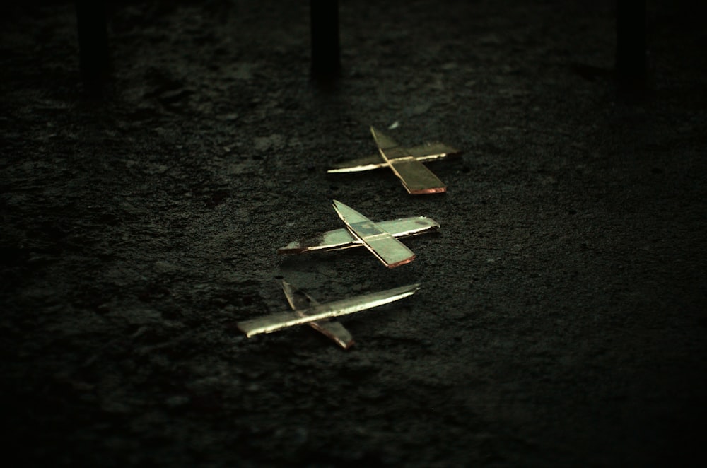 a group of small airplanes sitting on top of a dirt field