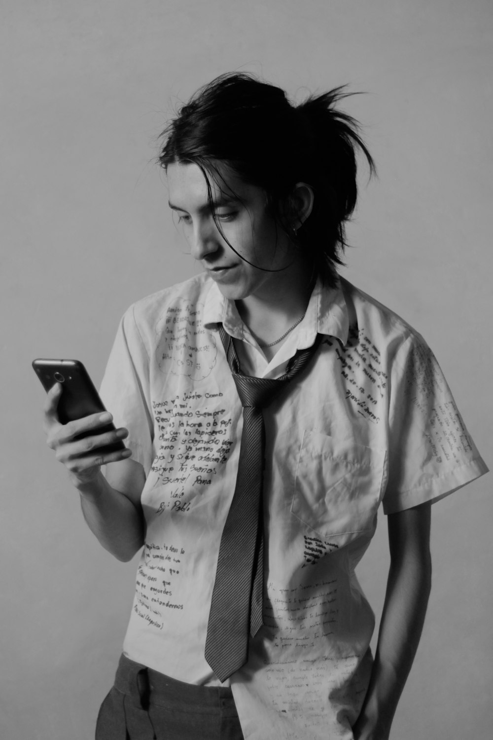 a woman wearing a tie and using a cell phone