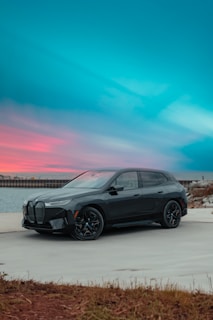 a grey bmw suv parked on the side of the road